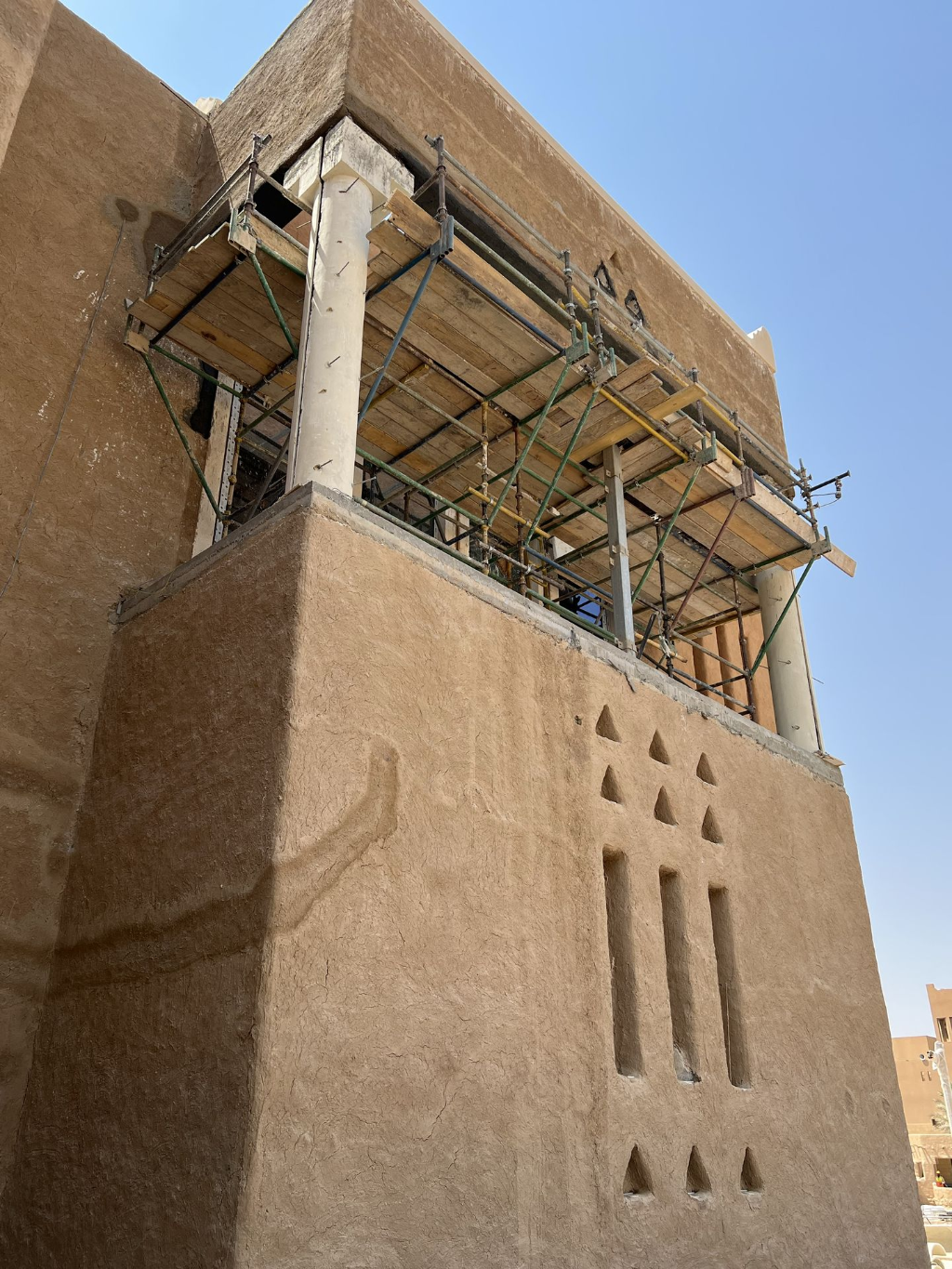 GRC façade panel installation showing textured vertical cladding on a Saudi project.